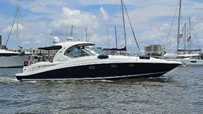 Sea Ray Sundancer cruising open harbor water near the marina