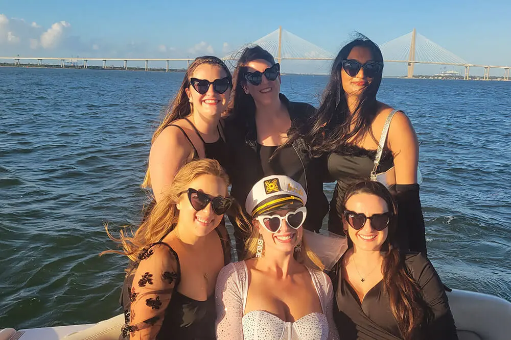 Bachelorette party group celebrating aboard a charter boat with the Ravenel Bridge behind them